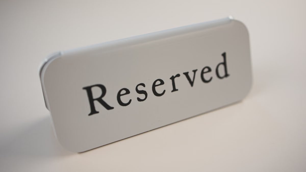 Metal signage with black letters saying Reserved on gray background used in cafes and restaurants